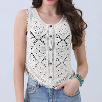 Woman wearing a white lace top and denim shorts on a light gray background