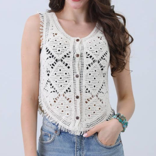 Woman wearing a white lace top and denim shorts on a light gray background
