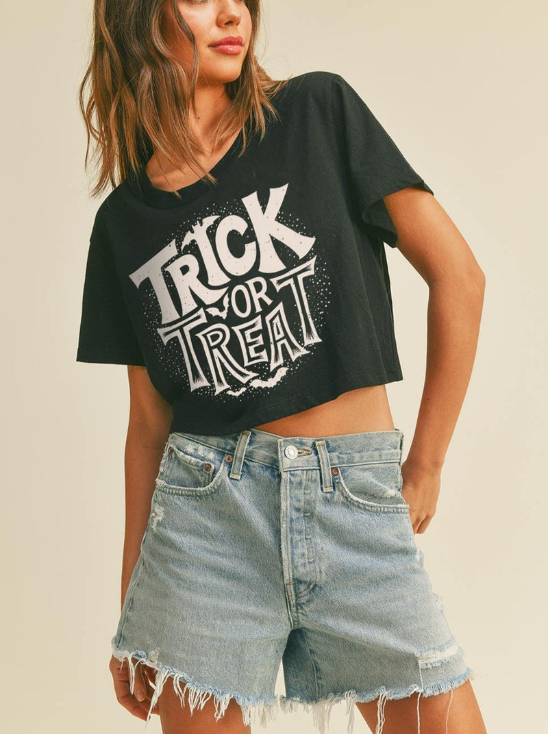 model wearing a halloween trick or treat cropped tee black shirt with white graphics